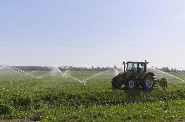 A tractor in a field with spray irrigation